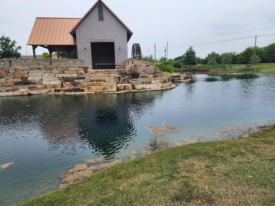 Constructed pond with stone edges and a finished outbuilding