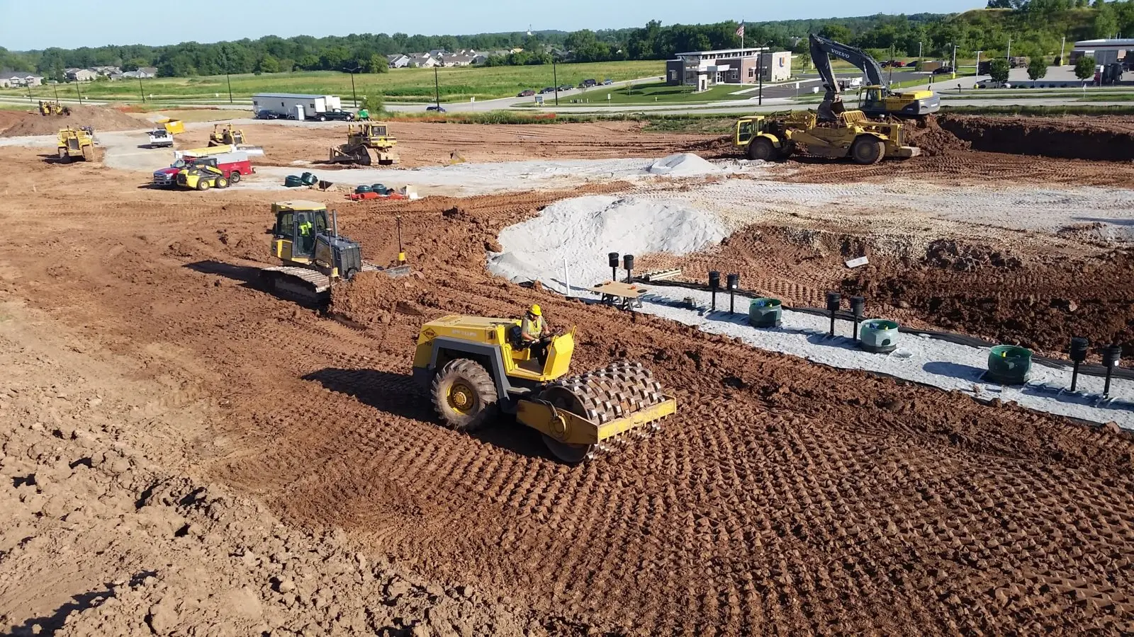 Heavy equipment grading and compacting a large construction site